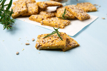 Gluten free Homemade Crackers and Rosemary for Appetizer on Blue Wooden Background.