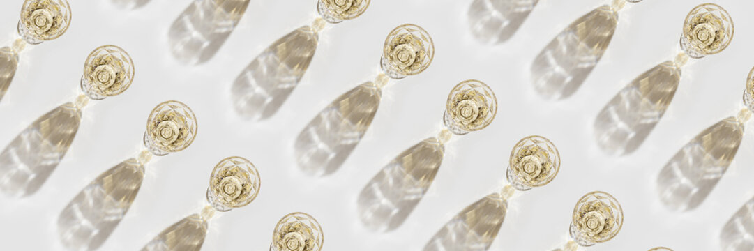 Top view of wineglass with white wine with beautiful shadows at sunlight, minimal graphic pattern, summer alcohol drink background, trend wide banner, creative aesthetic flat lay, still life