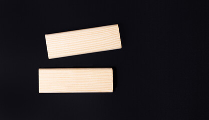 Two wooden jengs with a place to insert text on a black background. Copy space. Mockup