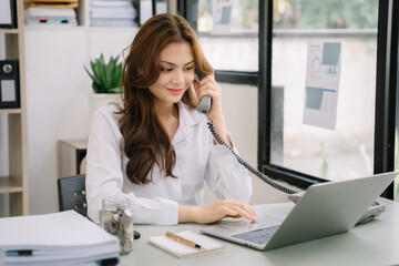 Obraz na płótnie Canvas Asian business woman using phone in office.