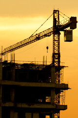 Silhouette construction site on sunset in evening time.Engineer and worker on building site.Construction sites and cranes are working in the industry new building business.