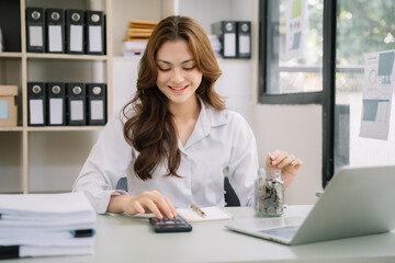 businesswoman hand puting coins in glass for saving money. concept finance and accounting in the home.