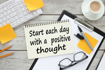Start each day with a grateful heart. text on white paper near the keyboard and feminine stickers. light wooden background