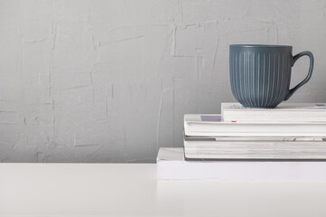 Still life with a gray cup and books. Scandinavian interior style.