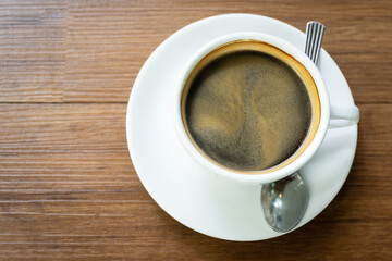 Top view Hot coffee in the white cup  on wooden table background..Cafe drinking menu black coffee at the restaurant with copy space.