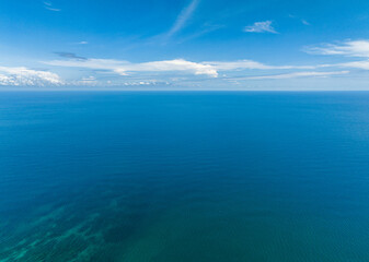 Beautiful white clouds on blue sky over calm sea. Tranquil sea harmony of calm water surface. Borneo, Malaysia.