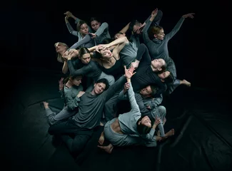 Foto op Canvas Top views of group of young people dancing contemp style against black studio background. Unique. Concept of modern freestyle dance, contemporary art, movements, hobby and creative lifestyle © master1305