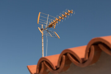 television antenna on a rooftop in front of blue sky