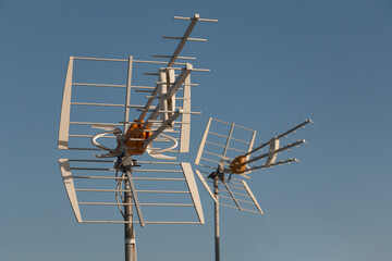 television antenna on a rooftop in front of blue sky