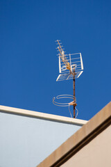 television antenna on a rooftop in front of a blue sky
