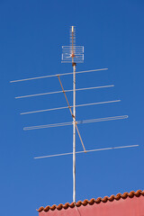 television antenna on a rooftop in front of a blue sky