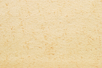 A sheet of old beige spotted cardboard texture as background
