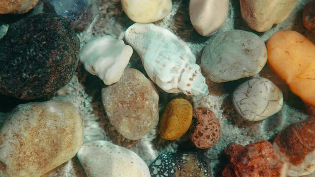 Top down view seabed background, sea floor beach sand ripple of water waves reflection, shells and stones. Sandy bottom surface summer. Underwater seafloor backdrop close-up