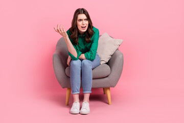 Full length photo of angry mad lady dressed green blouse sitting sofa screaming isolated pink color background - obrazy, fototapety, plakaty