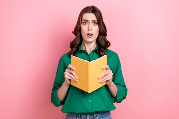 Photo of horrified frightened cute woman wavy hairdo dressed green shirt hold holding book impressed novel isolated on pink background - obrazy, fototapety, plakaty