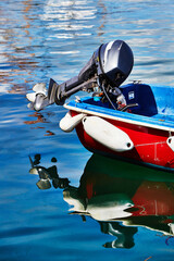 Isles of Scilly, United Kingdom - Detail of an outboard motor on a small boat floating in calm...