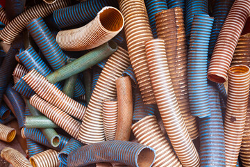 A pile of cut plastic corrugated multi-colored hoses. - obrazy, fototapety, plakaty