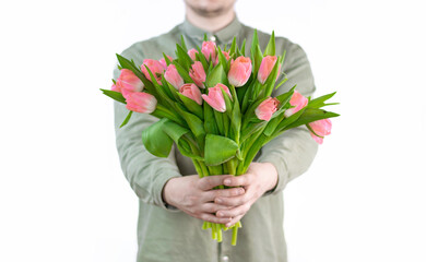 A man holds a basket with a bouquet of flowers in his hands on a white background. Gift, flower delivery, greeting card. spring tulips. Space for text on the right Close up