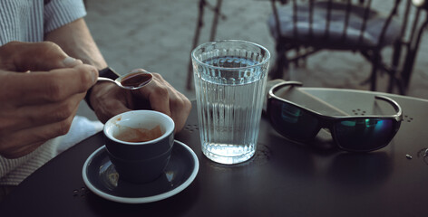 Elderly man drinking espresso coffee at an outdoor cafe