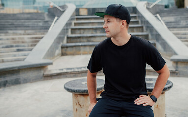 Fototapeta premium Young guy wearing black blank t-shirt and black cap. Mock-up for print. T-shirt template.