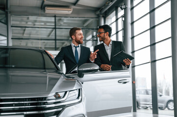 Man is consulting the customer in the car showroom