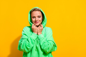 Photo of positive charming gorgeous lady wear green stylish hiding comfortable green hood warmth clothes isolated on yellow color background