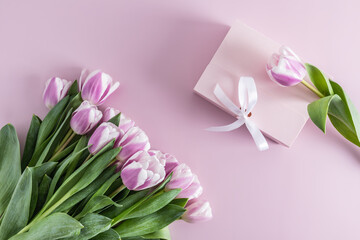 top view of a large bouquet of lilac tulips and a festive box with a gift. lilac background.