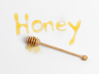 You are my candy girl. Studio shot of a word written in honey with a honey dipper beside it.