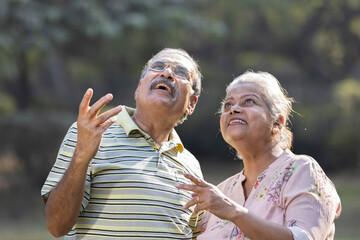 Laughing senior couple spending leisure time at park