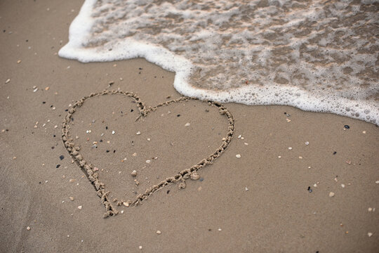 Heart drawing on sea sand,natural background.
