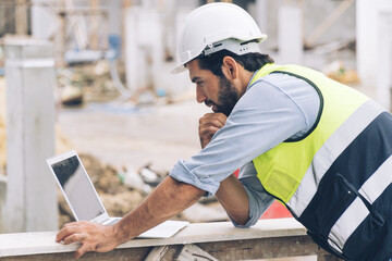 Construction engineer working on laptop on the construction site