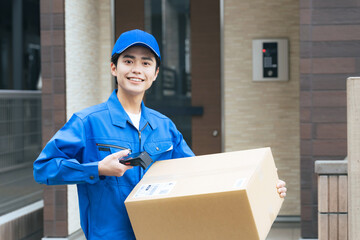 段ボールのバーコードを読み取る作業員　宅配便　デリバリースタッフ