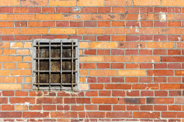 Background of an old brick wall with a window covered with a lattice