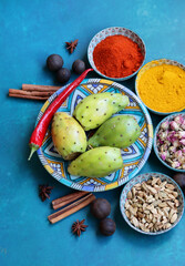 Still life with colorful fruit and spices on a table. Top view photo of grapefruit, paprika, turmeric powder, chili pepper, ginger, roses, lavender, anise and cinnamon. Blue background. 