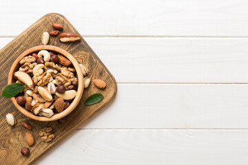 Fototapeta na wymiar mixed nuts in bowl. Mix of various nuts on colored background. pistachios, cashews, walnuts, hazelnuts, peanuts and brazil nuts