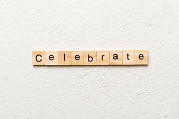 Celebrate word written on wood block. Celebrate text on cement table for your desing, concept