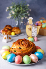 Craffin (Cruffin) with raisins and candied fruits. Traditional Easter Bread Kulich and painted eggs on a gray background. Easter Holiday. Close-up, selective focus.
