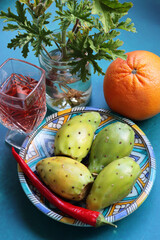 Opuntia cactus fruit close up photo. Eastern Prickly Pear on a blue decorative plate. Still life with fruit on a blue background. Food of Middle East. 