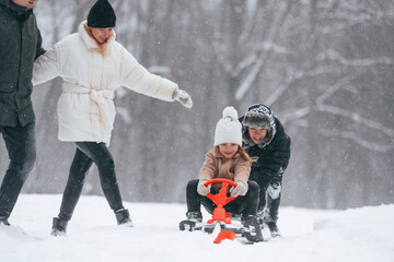 Sled ride. Happy family is outdoors, enjoying snow time at winter together
