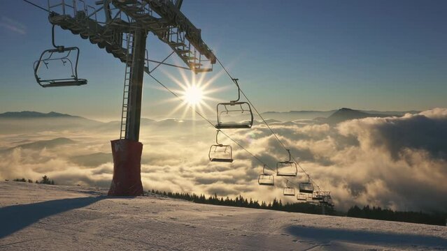 Beautiful weather for skiing in winter ski alpine mountains resort with empty chairlift and groomers on fresh snowy slopes