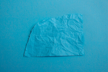Creased blue paper on a blue background with copy space for text. Torn paper background.