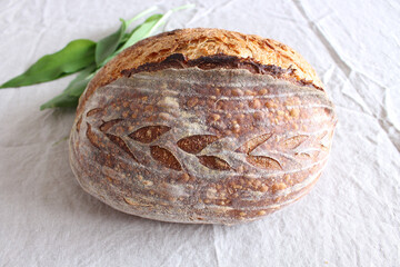 Bread close-up freshly baked sourdough bread with a golden crust on a table in the kitchen.