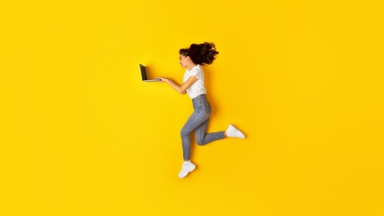 Fototapeta na wymiar Happy Woman Using Laptop Computer Browsing Internet Over Yellow Background