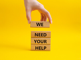 We need your help symbol. Wooden blocks with words We need your help. Beautiful yellow background. Businessman hand. Business and We need your help concept. Copy space.