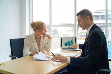 Professional business boss talking with secretary in modern office with waindow