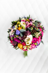 sehr bunter farbenfroher Brautstrauß auf weißem Hintergrund bei Hochzeit