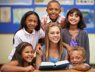 Sharing a book in English class. Portrait of a group of students reading from a book in class.