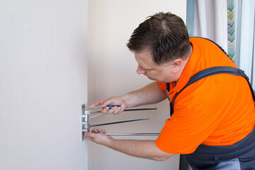 Man installs towel dryer on balcony.