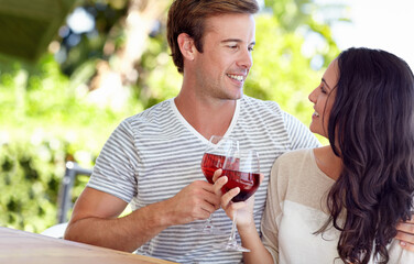 Cheers to us. A young couple drinking a glass of wine on their patio.