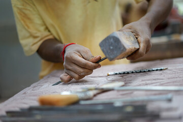 Close up on hand working on stone sculptures